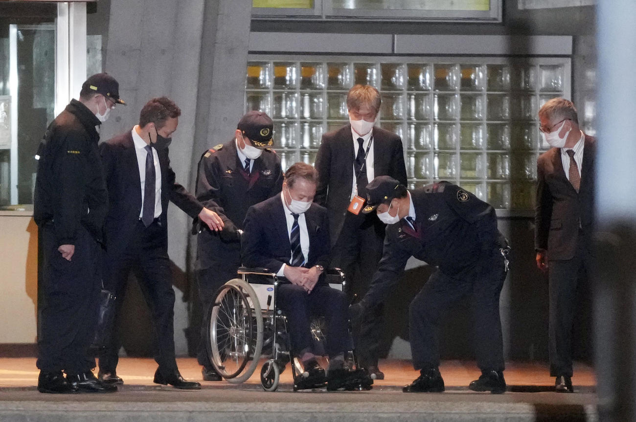 保釈され、職員に助けられながら車いすで東京拘置所を出る高橋治之元理事（＝19時半ごろ）（撮影・狩俣裕三）