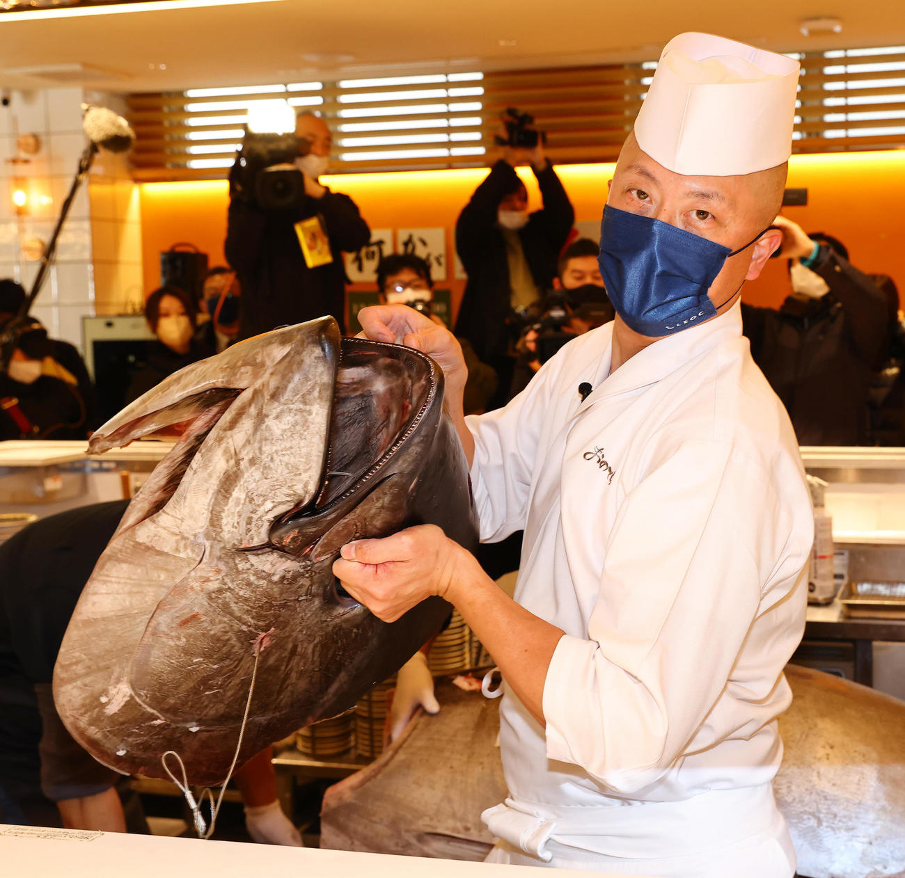 切り落とされた一番マグロの頭を手にするおのでら坂上暁史料理長（撮影・垰建太）