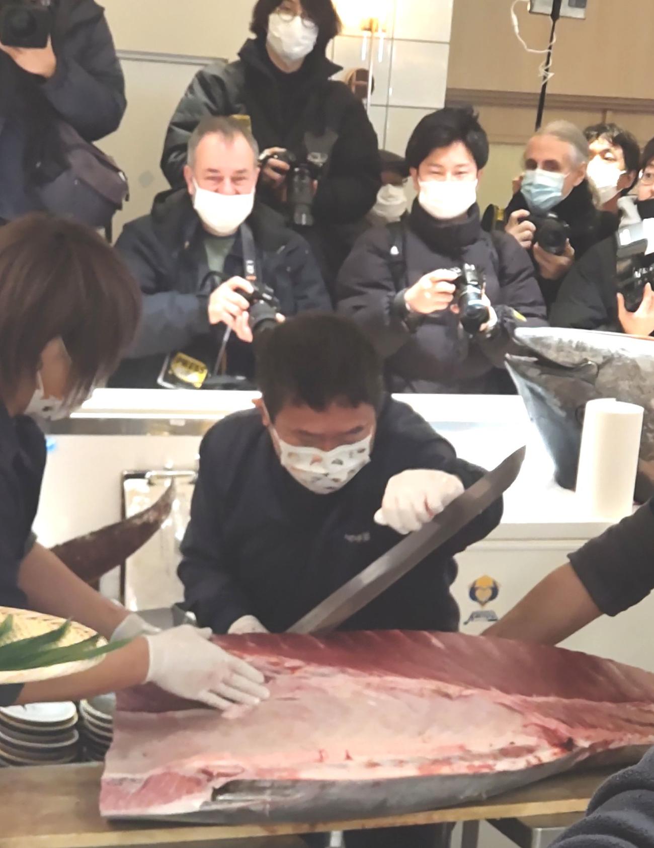 やま幸の山口幸隆社長は報道陣に見守られながら、刀のようなマグロ専用の包丁で一番マグロの解体を実演した（撮影・寺沢卓）