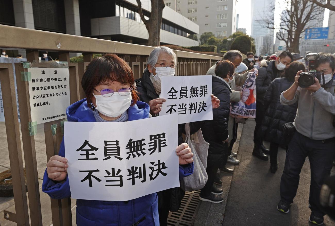 福島第1原発事故を巡る東京電力旧経営陣3人の控訴審判決を受け、「全員無罪　不当判決」と書かれた紙を掲げる原発で被害に遭った女性ら（共同）