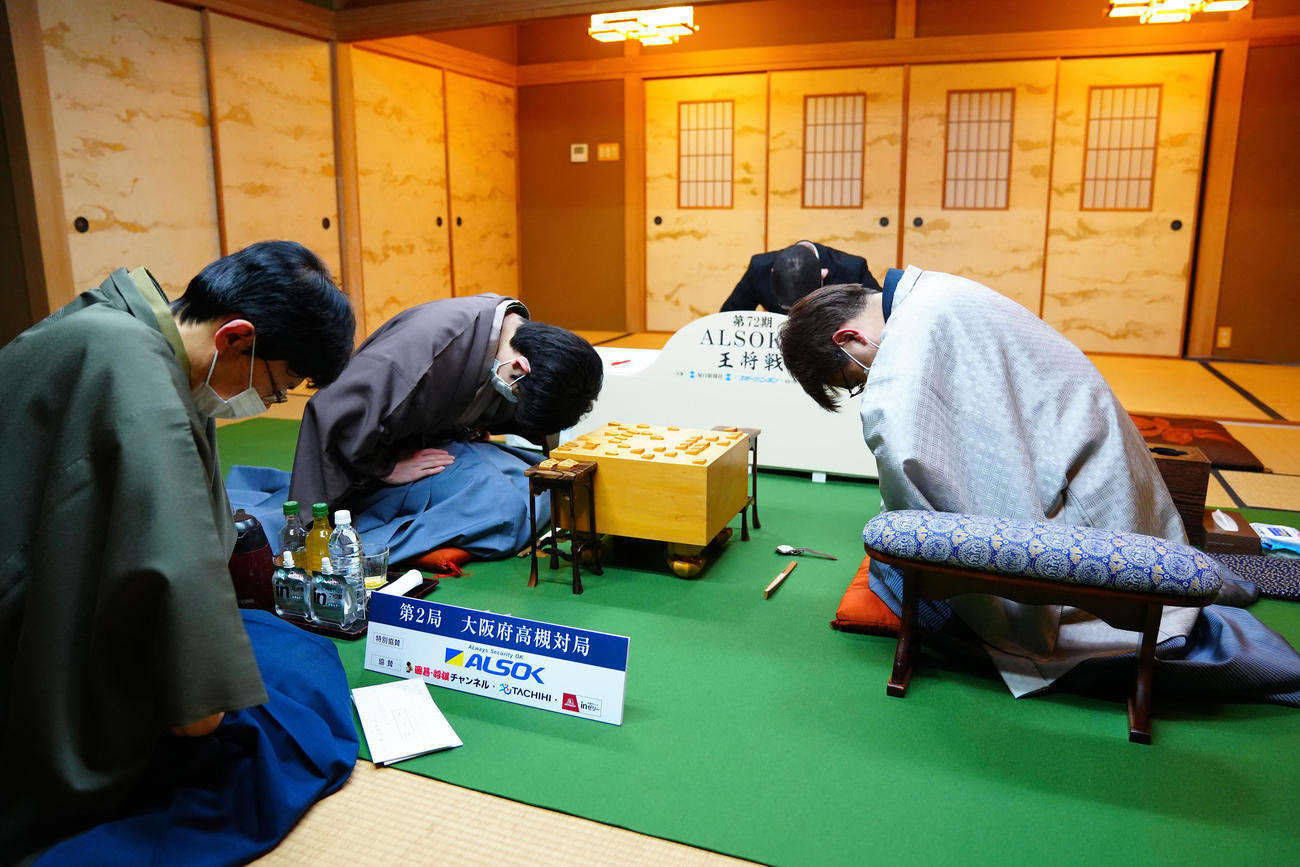 1日目の対局を終え、一礼する藤井聡太王将（左から2人目）と羽生善治九段（代表撮影）