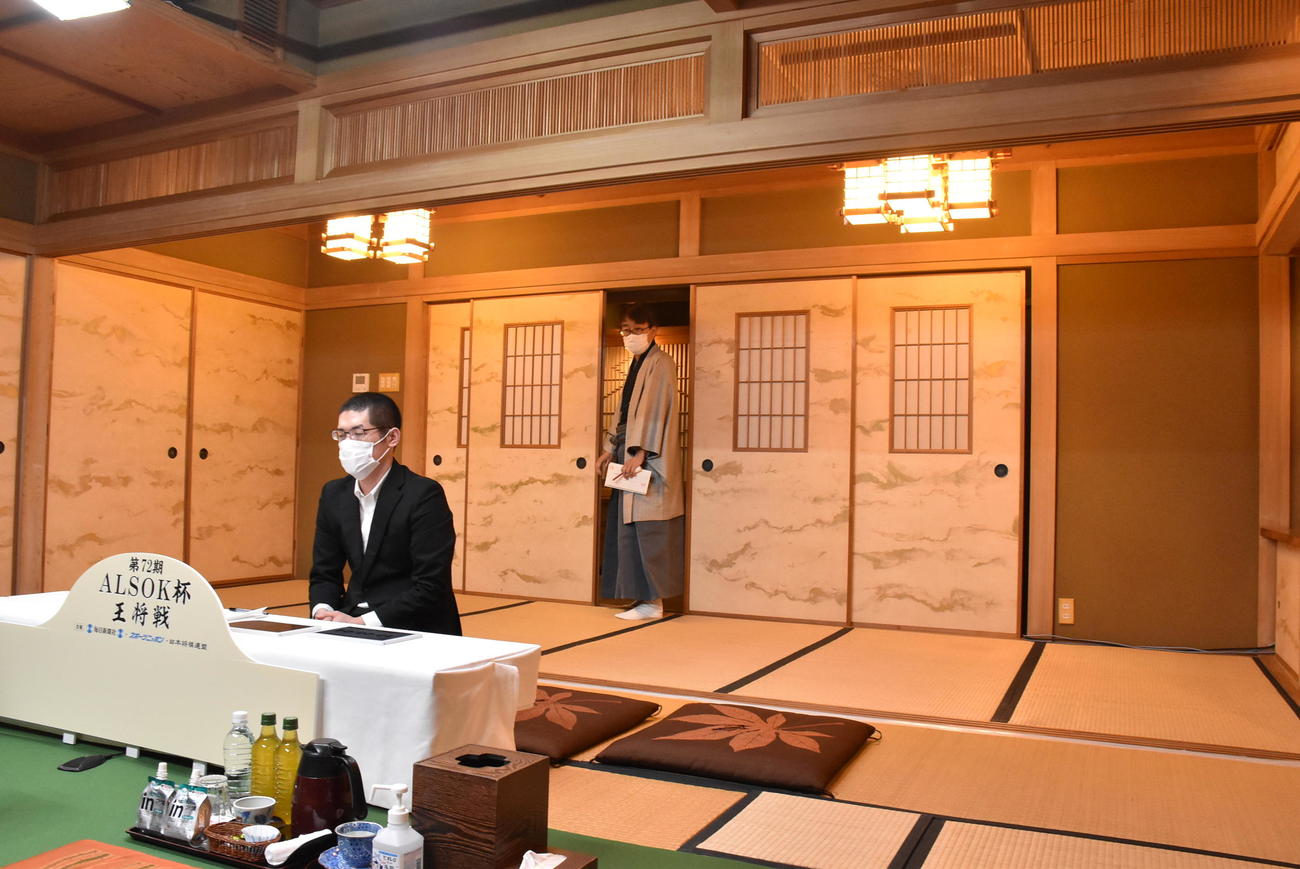 封じ手の封筒を持ち、入室する羽生善治九段（日本将棋連盟提供）