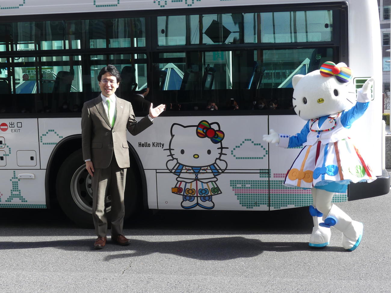 次世代バイオ燃料を使った都営バスの出発式でポーズを取るユーグレナの出雲充社長（左）とハローキティ（撮影・中山知子）