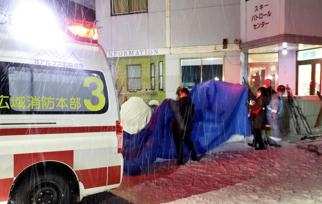 雪崩が発生した現場近くの栂池高原スキー場で、シートに隠され救急車に乗り込む負傷者ら
