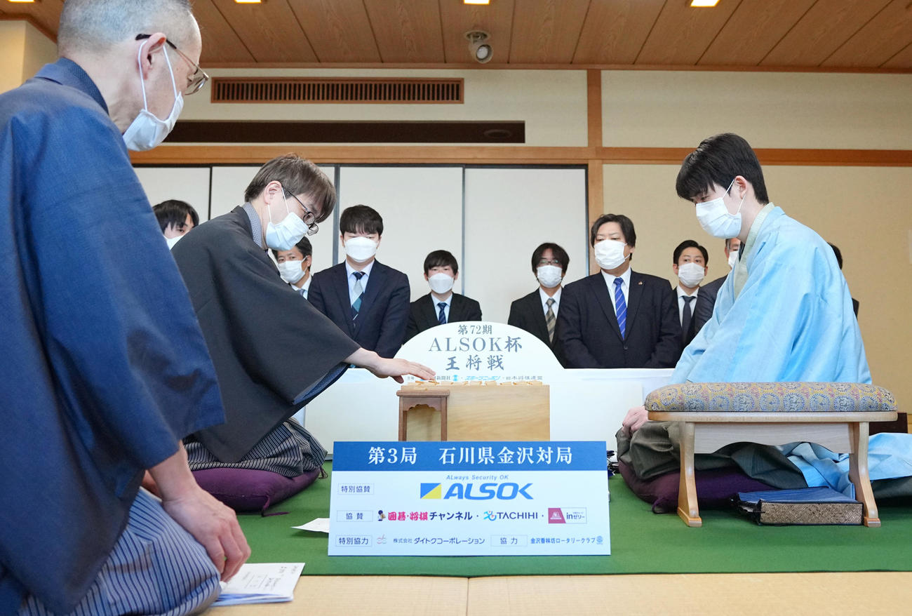 立会の島朗九段（左端）が開いた封じ手を指す挑戦者の羽生善治九段（左から2人目）。右は藤井聡太王将（代表撮影）