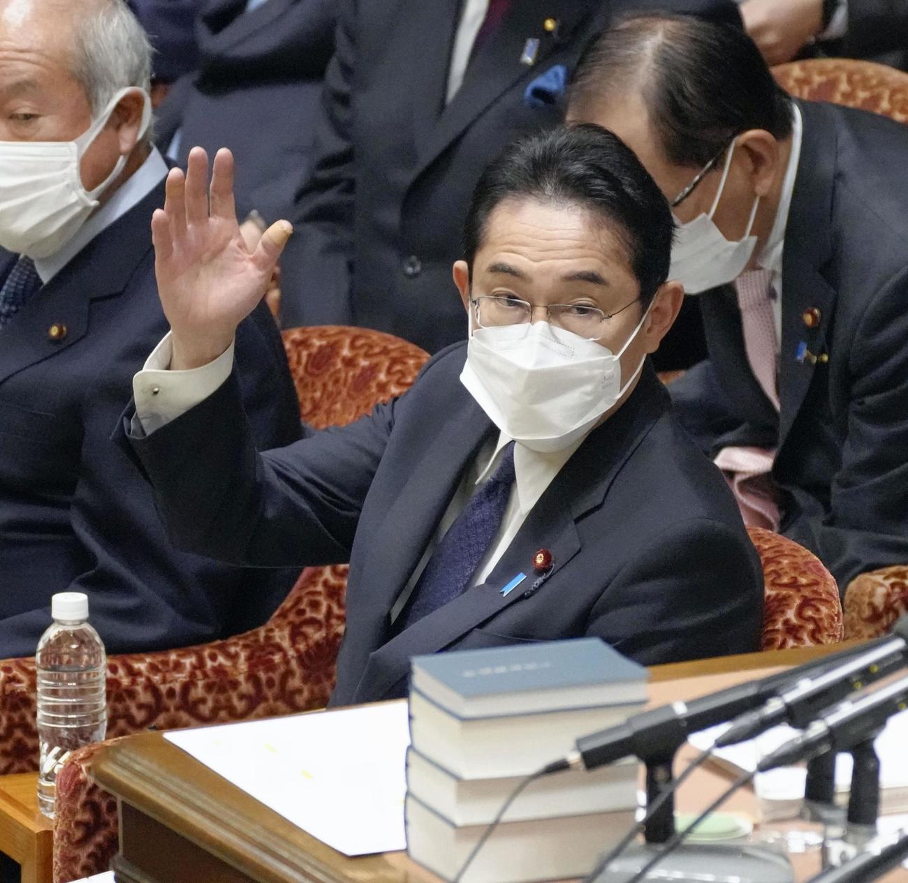 衆院予算委で答弁のため挙手する岸田首相（共同）