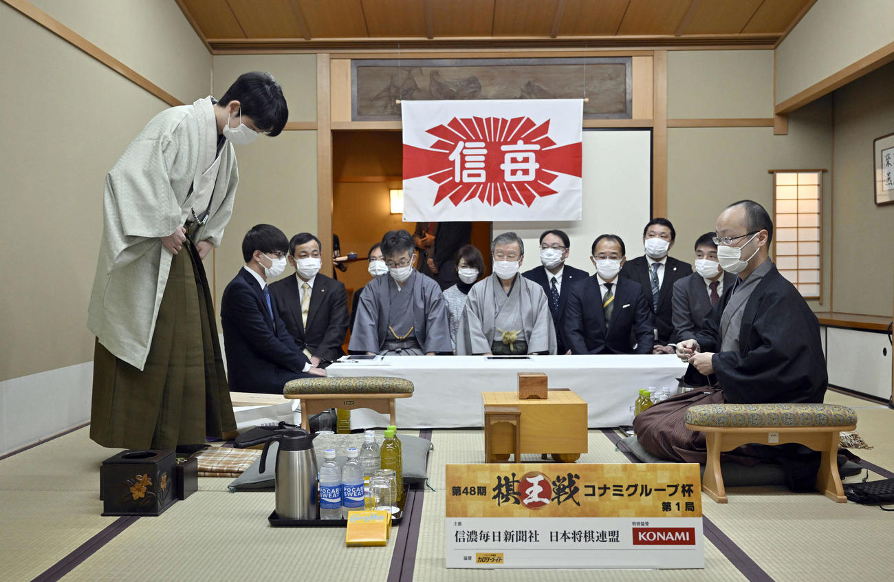 渡辺明棋王（右）の待つ対局室に入室する藤井聡太五冠（代表撮影）
