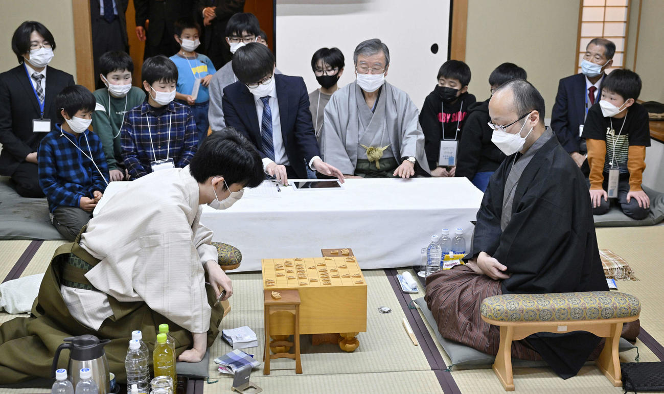 子どもたちが見学する中、対局する藤井聡太五冠（手前左）と渡辺明棋王（同右）（代表撮影）