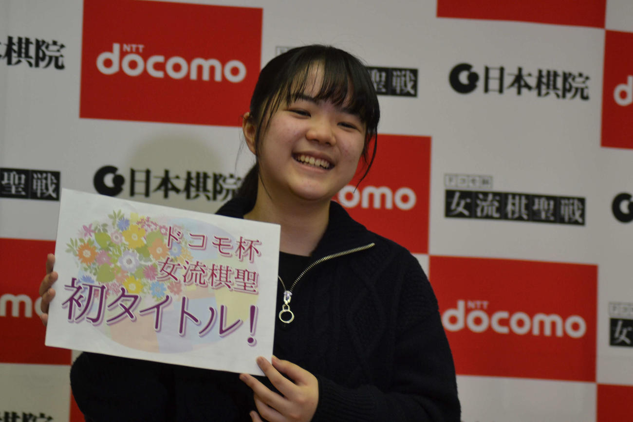 初タイトルのボードを手に笑顔を見せる仲邑菫女流棋聖
