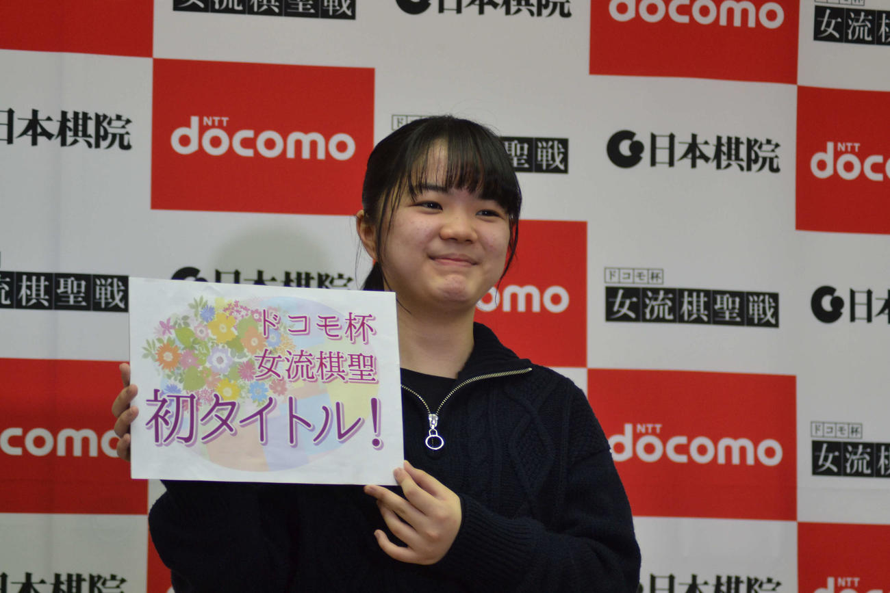 初タイトルのボードを手に笑顔を見せる仲邑菫女流棋聖