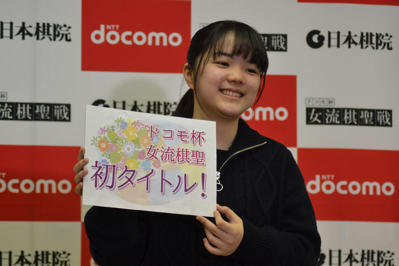初タイトルのボードを手に笑顔を見せる仲邑菫女流棋聖