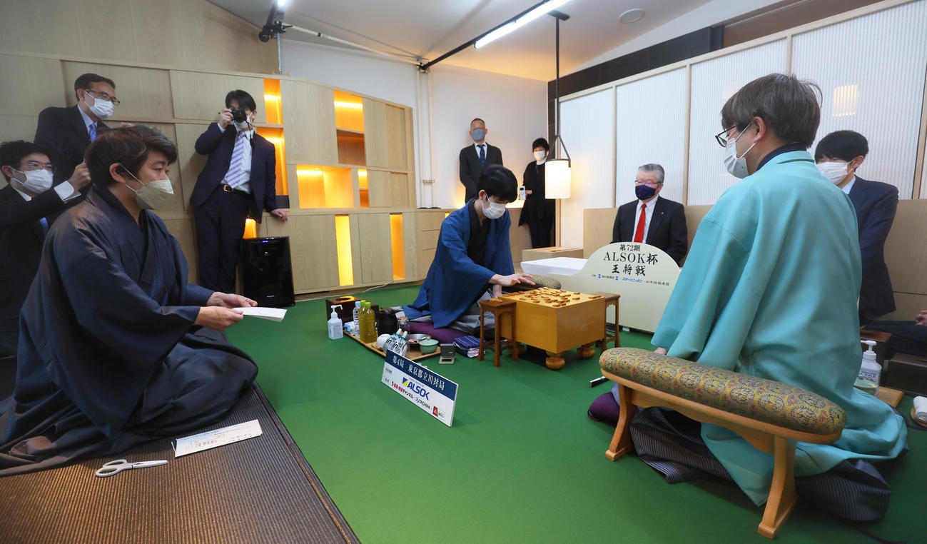 開封した封じ手を見せる立会の森内九段（左）。中央は封じ手を指す藤井王将、右は羽生九段（代表撮影）