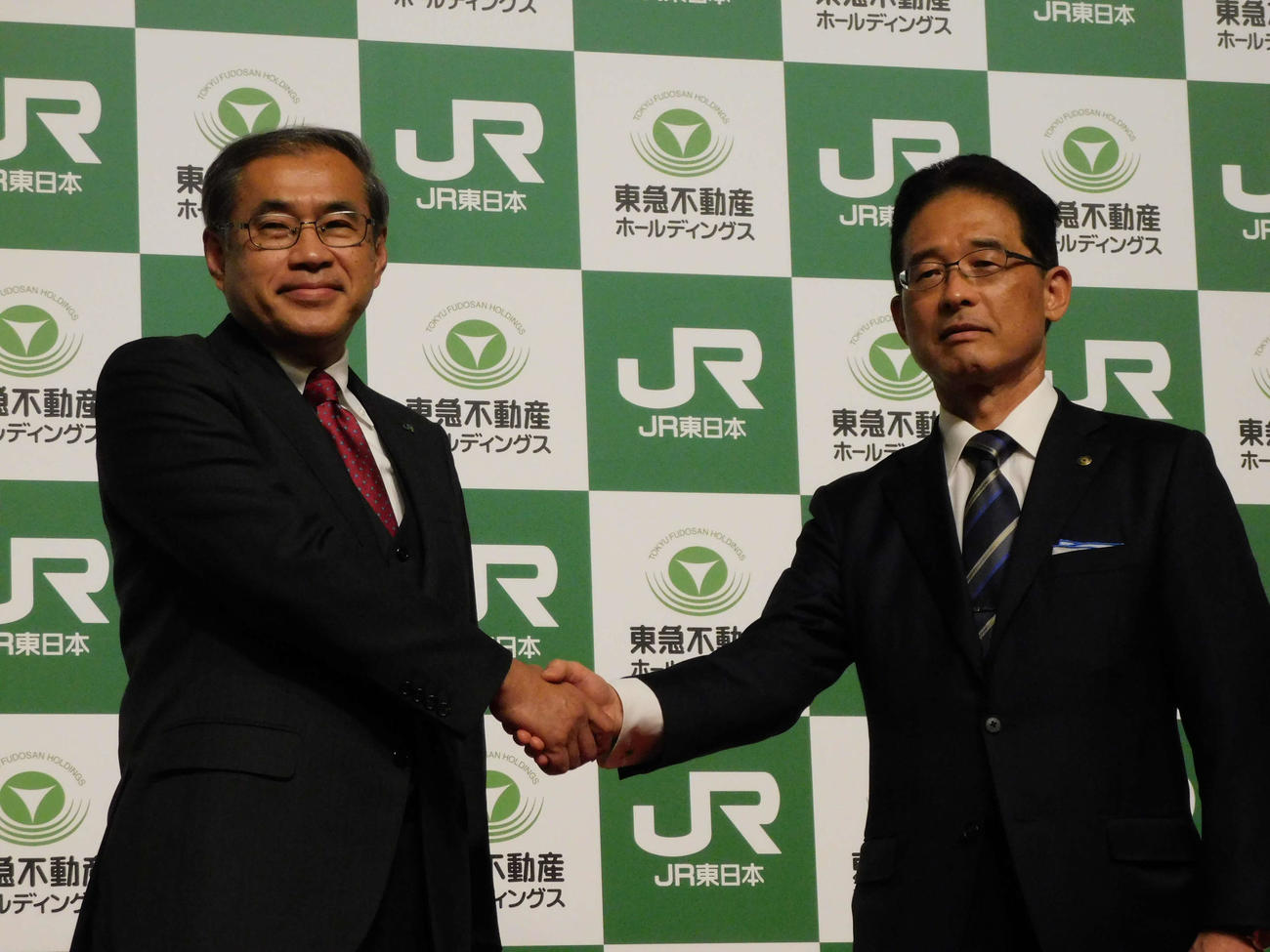 業務提携契約締結を発表し握手する深澤祐二JR東日本社長（左）と西川弘典東急不動産ホールディングス社長