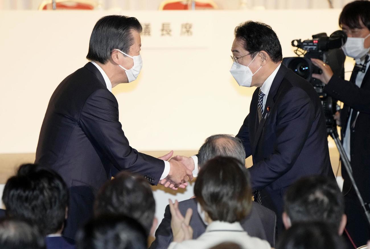 自民党大会で公明党の山口代表（左）と握手する岸田首相（共同）