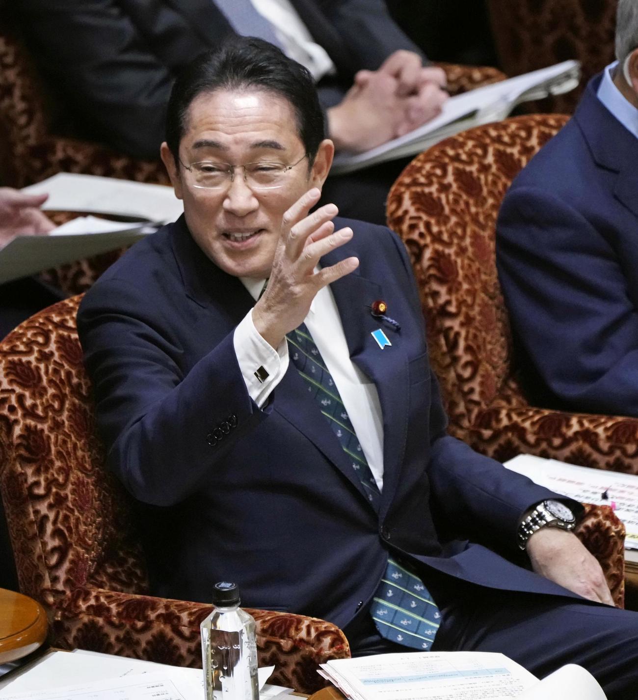 参院予算委で答弁のため挙手する岸田首相（共同）