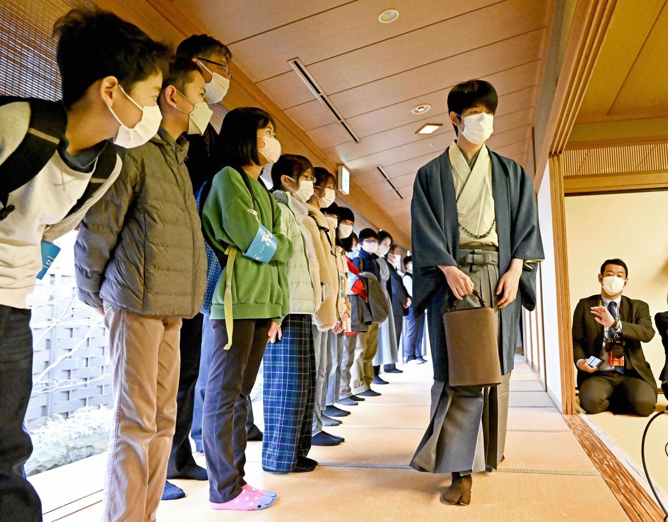 第48期棋王戦コナミグループ杯5番勝負第3局で見学する子どもたちの前を通り、対局室に入室する藤井聡太5冠（代表撮影）