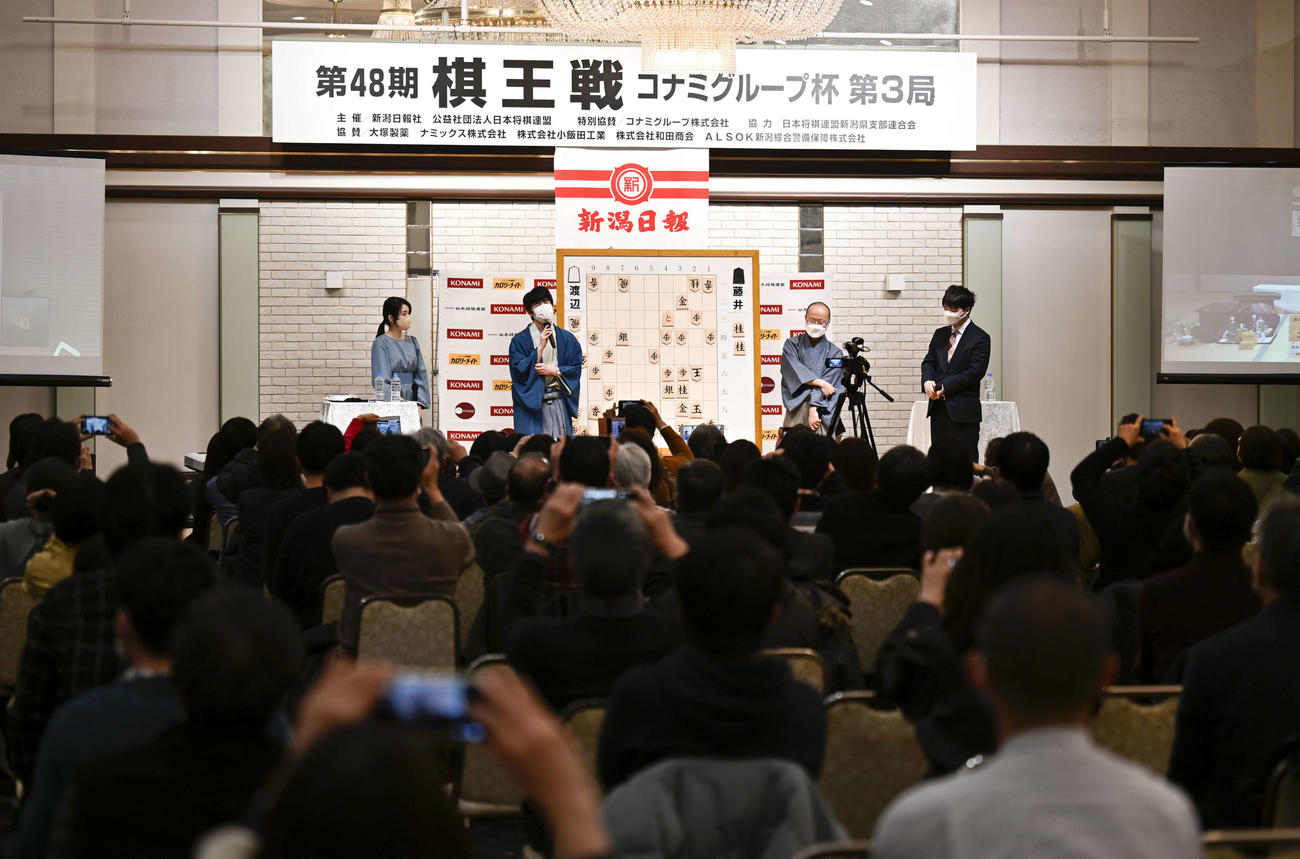 第48期棋王戦コナミグループ杯5番勝負第3局　藤井聡太5冠対渡辺明棋王　大盤解説会場であいさつする渡辺明棋王と（右から2人目）と藤井聡太5冠（右から3人目）（代表撮影）