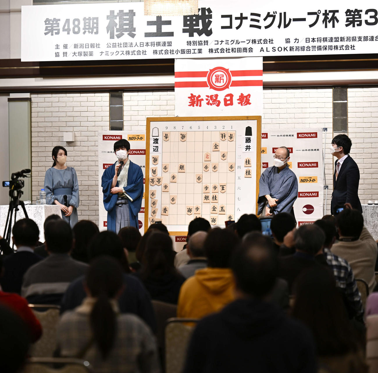 第48期棋王戦コナミグループ杯5番勝負第3局　藤井聡太5冠対渡辺明棋王　大盤解説会場で感想を述べる藤井聡太5冠（左から2人目）と渡辺明棋王（同3人目）（代表撮影）