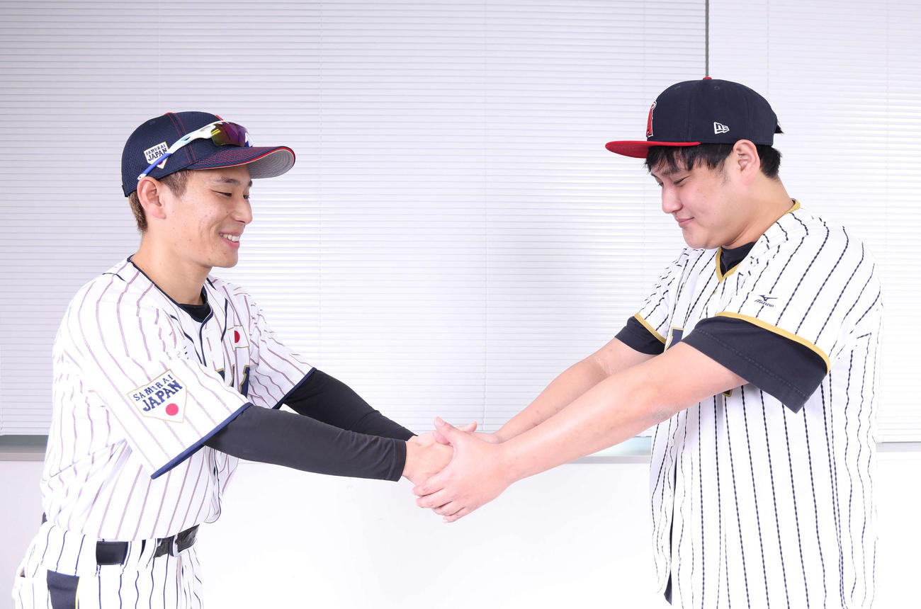 3月6日の一面に掲載された「侍ジャパンに合流した吉田と握手を交わす大谷」を再現する小城卓三（吉田も）（左）と太谷翔平（撮影・河田真司）