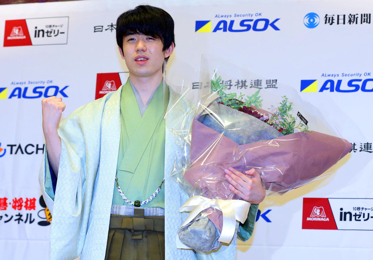 第72期王将戦7番勝負第6局　防衛を果たし、花束を手にガッツポーズをする藤井王将（撮影・屋方直哉）