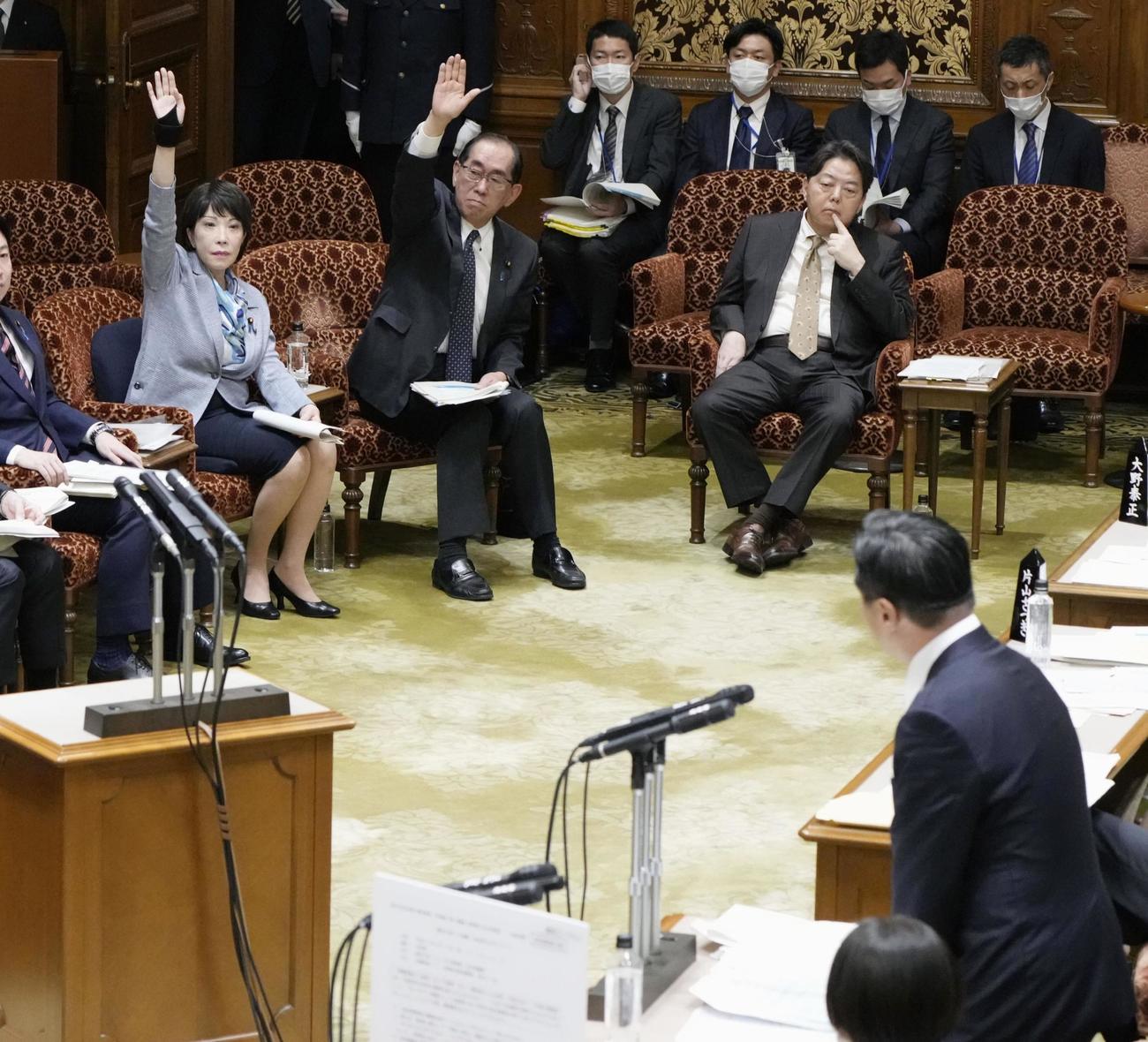 参院予算委で立憲民主党の福山哲郎氏（右下）の質問に挙手する高市経済安保相（左上）と松本総務相（共同）