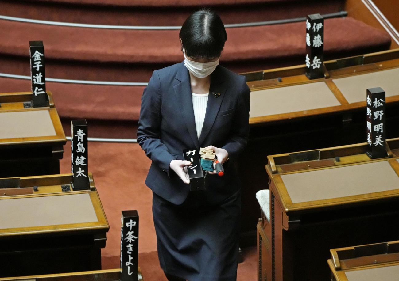 除名され取り外された政治家女子48党のガーシー氏の氏名標を手にする職員（共同）
