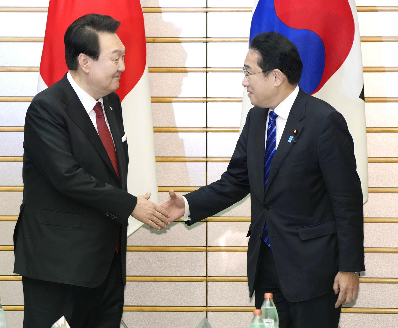 首脳会談で握手する岸田首相（右）と韓国の尹錫悦大統領（共同）