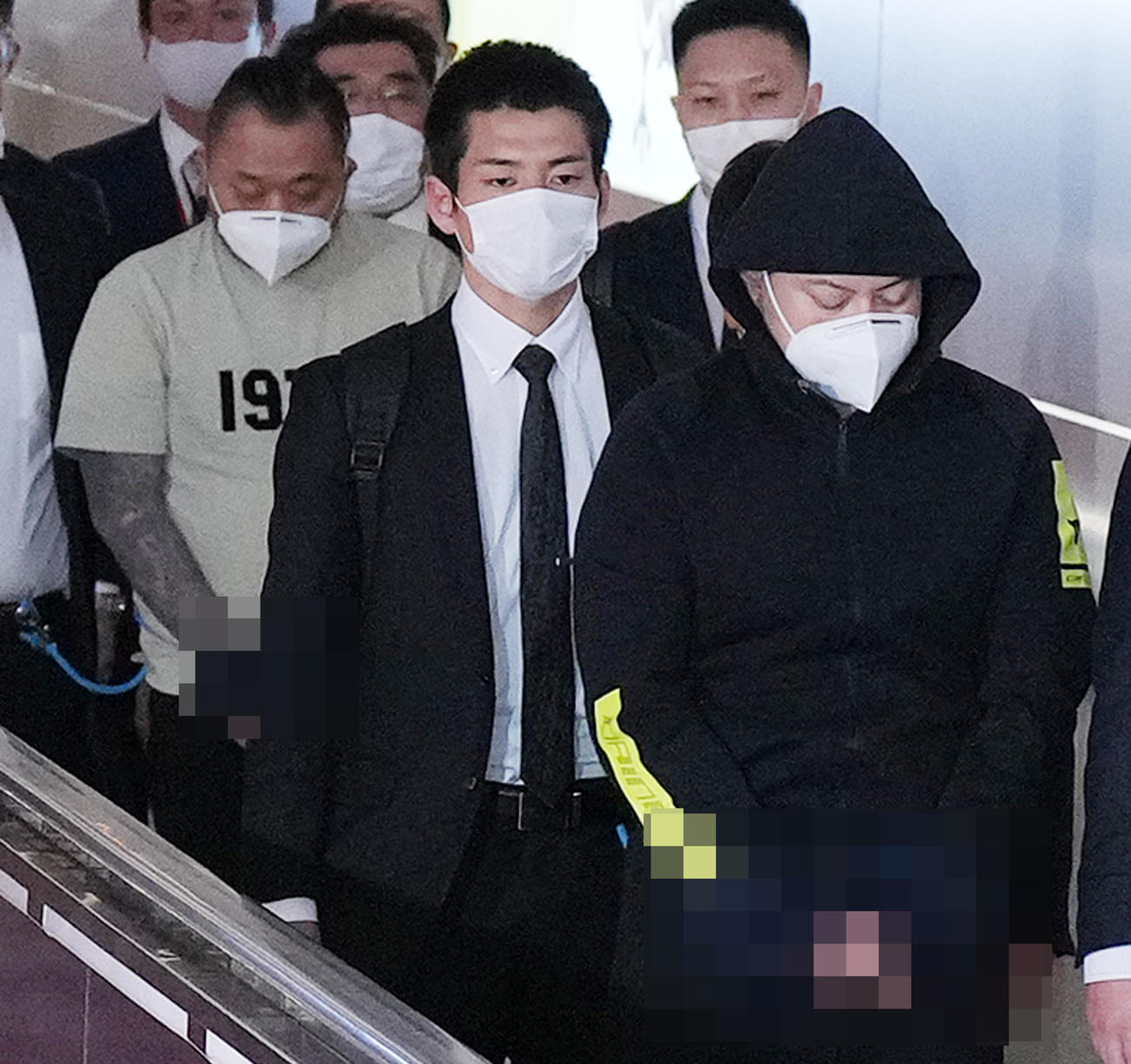 2月9日、フィリピンのマニラから強制送還され日本に到着した渡辺優樹容疑者（右端）と小島智信容疑者（左端）（写真は一部加工）