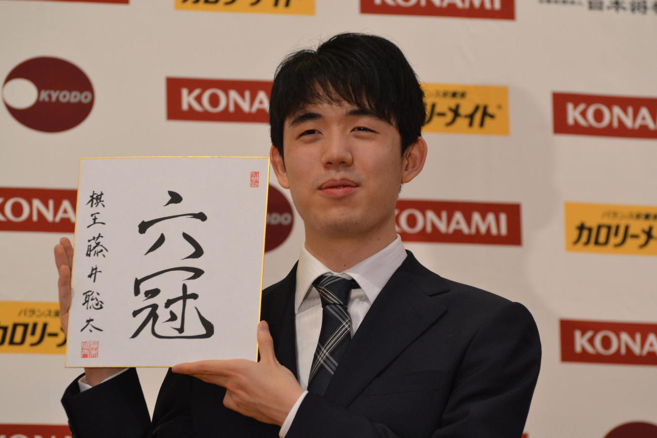 初の棋王獲得と史上最年少6冠達成から一夜明けた会見で「六冠」と揮毫（きごう）した色紙を手にする藤井聡太棋王
