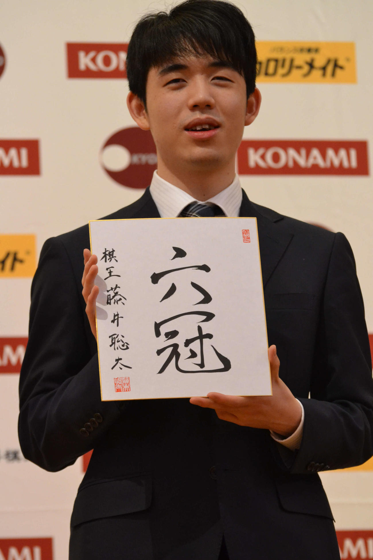 初の棋王獲得と史上最年少6冠達成から一夜明けた会見で「六冠」と揮毫（きごう）した色紙を手にする藤井聡太棋王