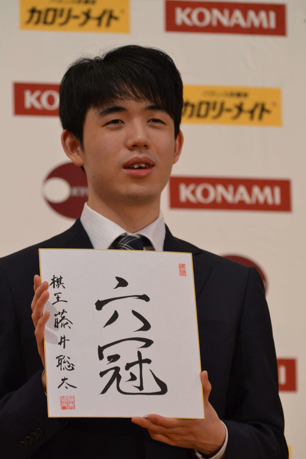 初の棋王獲得と史上最年少6冠達成から一夜明けた会見で「六冠」と揮毫（きごう）した色紙を手にする藤井聡太棋王
