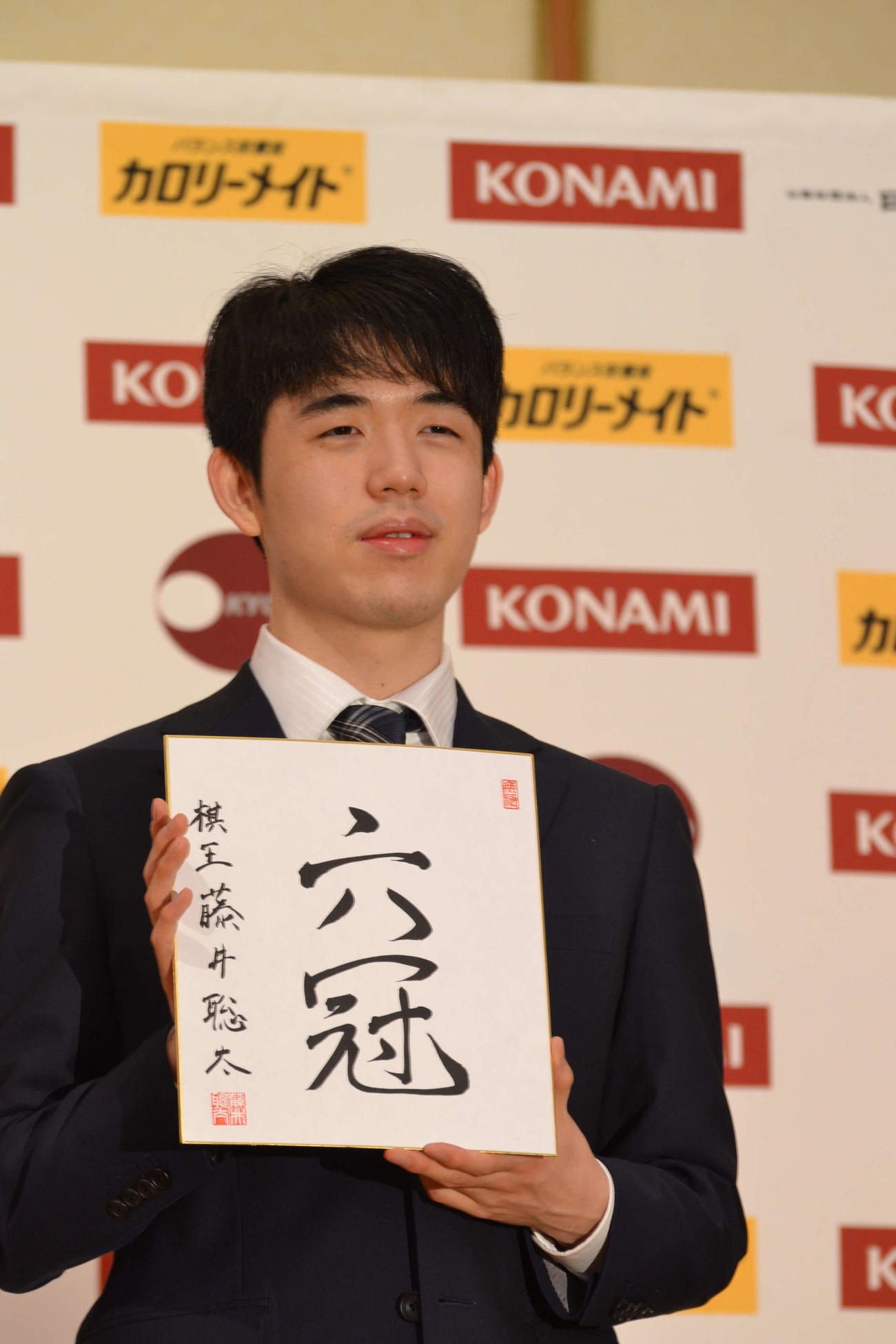 初の棋王獲得と史上最年少6冠達成から一夜明けた会見で「六冠」と揮毫（きごう）した色紙を手にする藤井聡太棋王