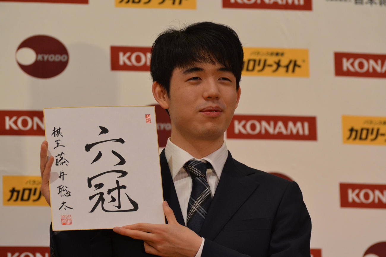 初の棋王獲得と史上最年少6冠達成から一夜明けた会見で「六冠」と揮毫（きごう）した色紙を手にする藤井聡太棋王