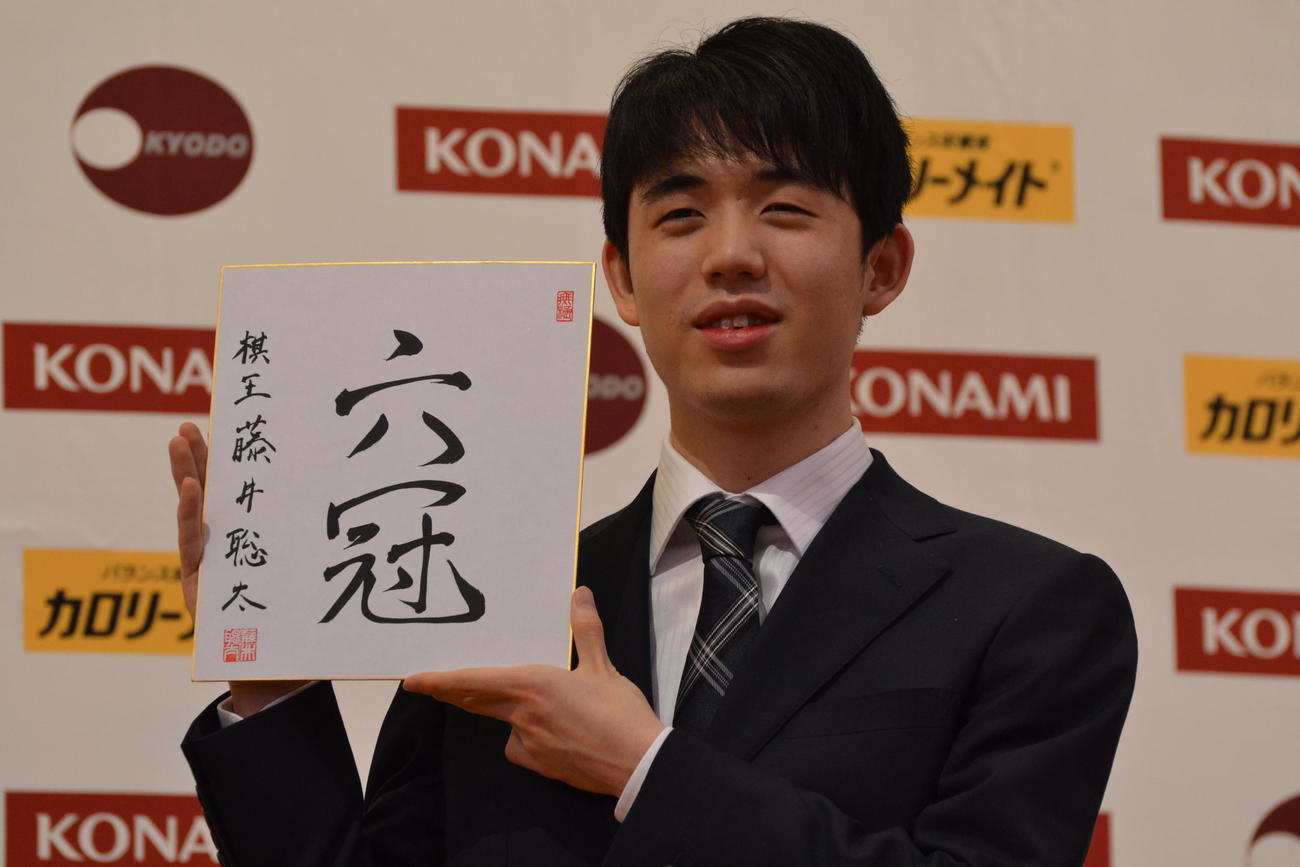 初の棋王獲得と史上最年少6冠達成から一夜明けた会見で「六冠」と揮毫（きごう）した色紙を手にする藤井聡太棋王