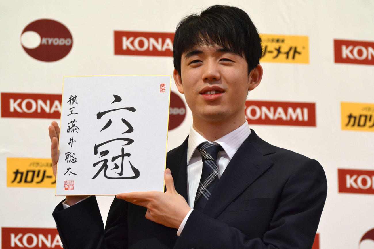 初の棋王獲得と史上最年少6冠達成から一夜明けた会見で「六冠」と揮毫（きごう）した色紙を手にする藤井聡太棋王