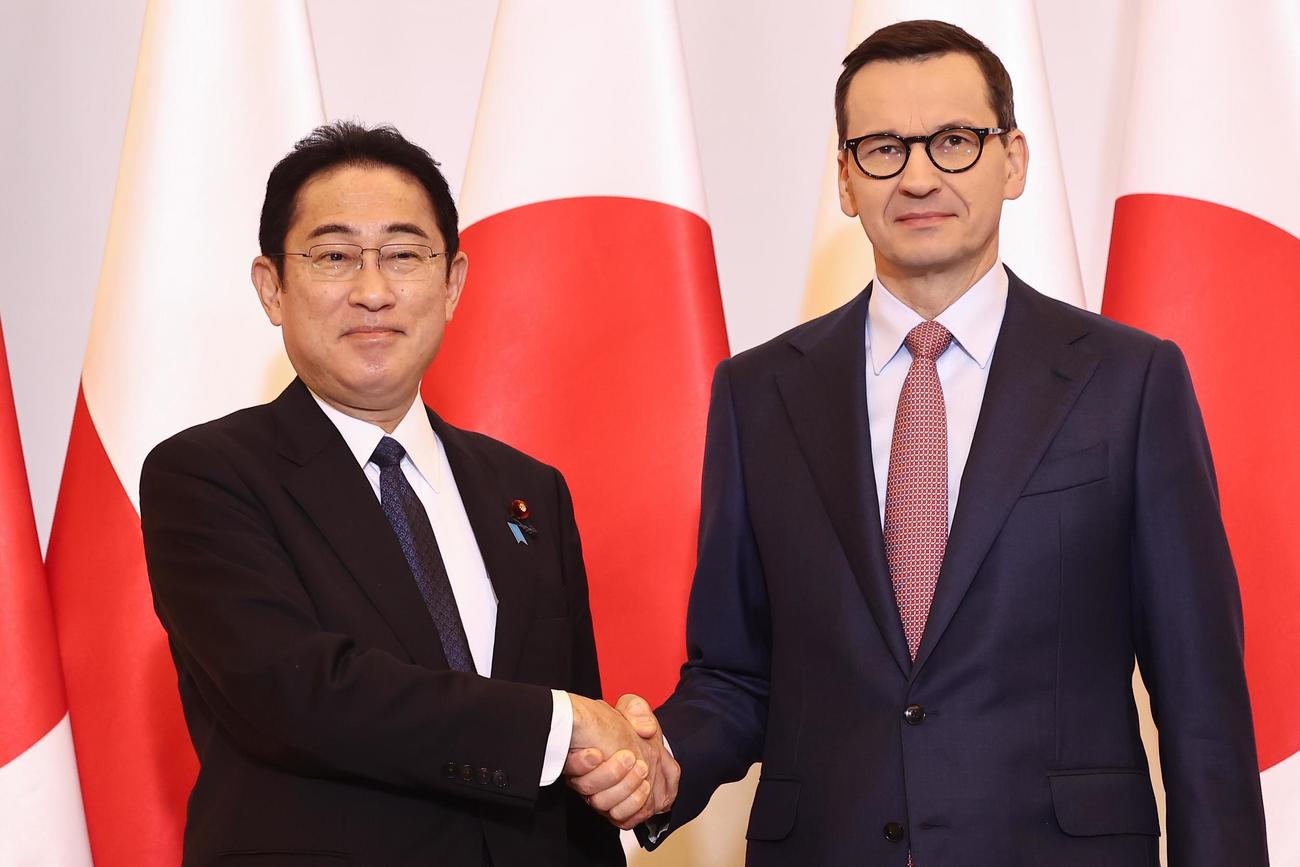 22日、ポーランド・ワルシャワでモラウィエツキ首相（右）と写真に納まる岸田文雄首相（ゲッティ＝共同）