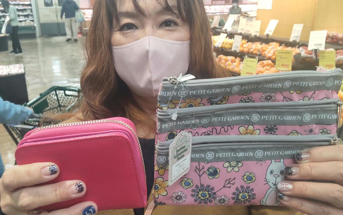 ヌートバーの活躍で記念セールを行っている丸広百貨店東松山店で財布（左）とポーチを「これで1000円以内です」と大喜びの近所に住む主婦の小川悟美さん（撮影・寺沢卓）