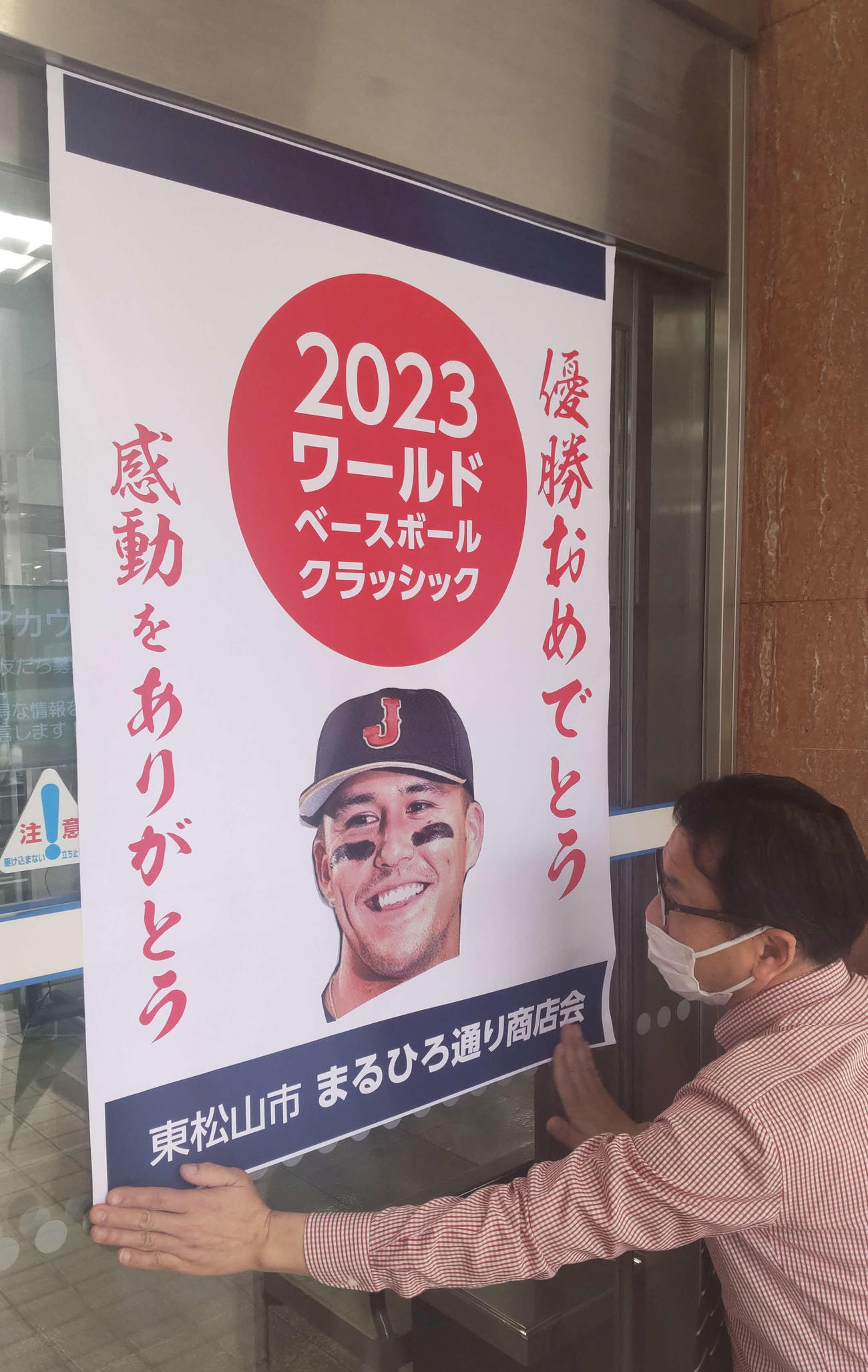 ヌートバーの母久美子さんの出身地、東松山市の丸広百貨店入り口では杉田明男店長が、WBC優勝を祝う地元商店街のポスターをはりだした（撮影・寺沢卓）