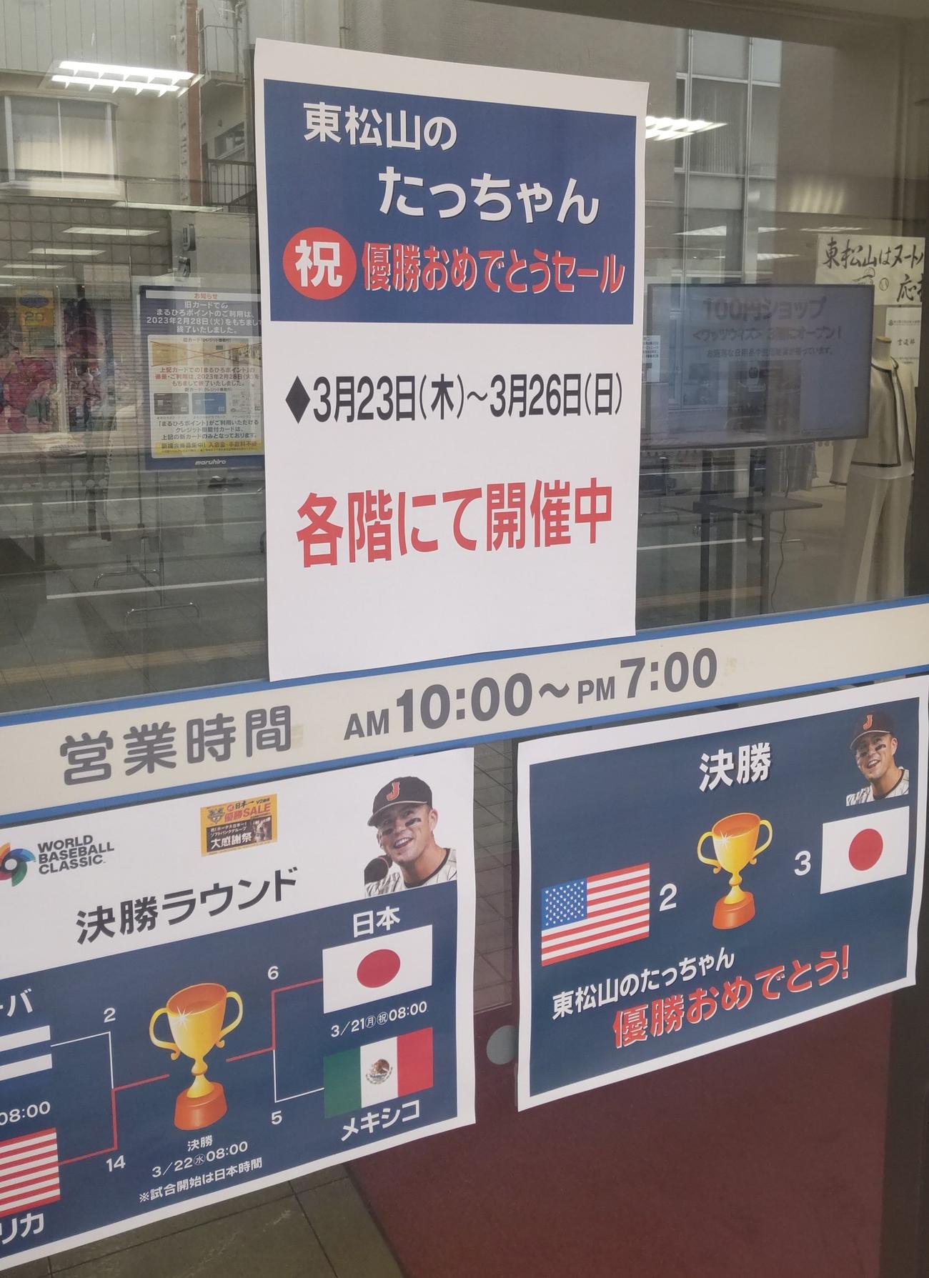 丸広百貨店東松山店の入り口には23日から始まった「東松山のたっちゃん　祝優勝おめでとうセール」とWBCの侍ジャパンの優勝の足跡がはられていた（撮影・寺沢卓）