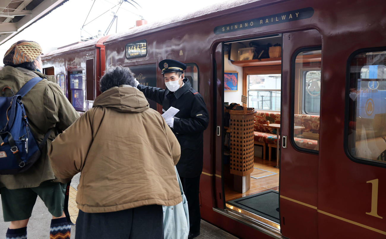 しなの鉄道　乗客に案内するろくもんの車掌さん（撮影・浅見桂子）