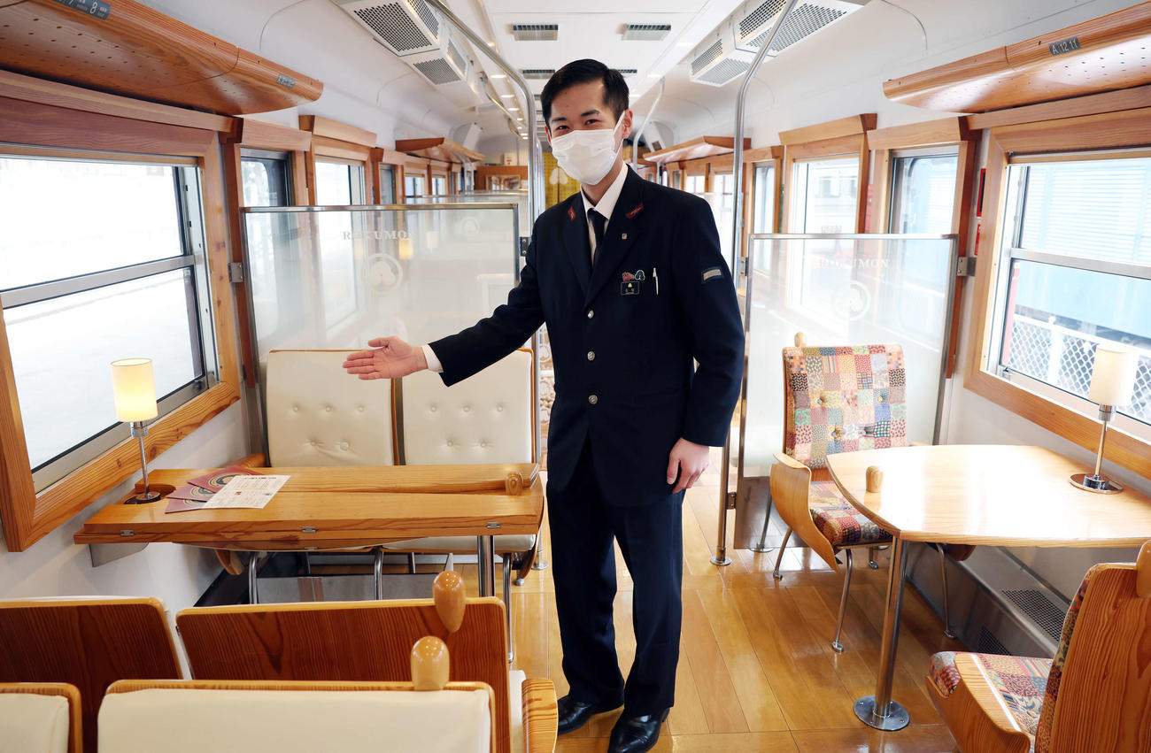 しなの鉄道　1号車のシンプルモダンな車内を案内する車掌さん（撮影・浅見桂子）