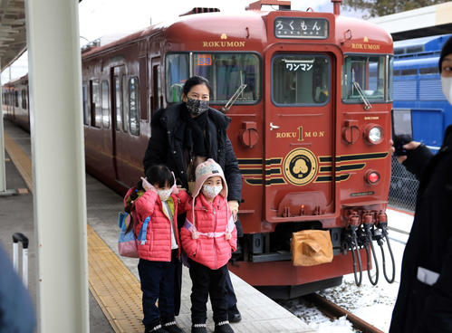 しなの鉄道 朝の軽井沢駅で、ろくもんと記念撮影する家族(撮影・浅見桂子)
