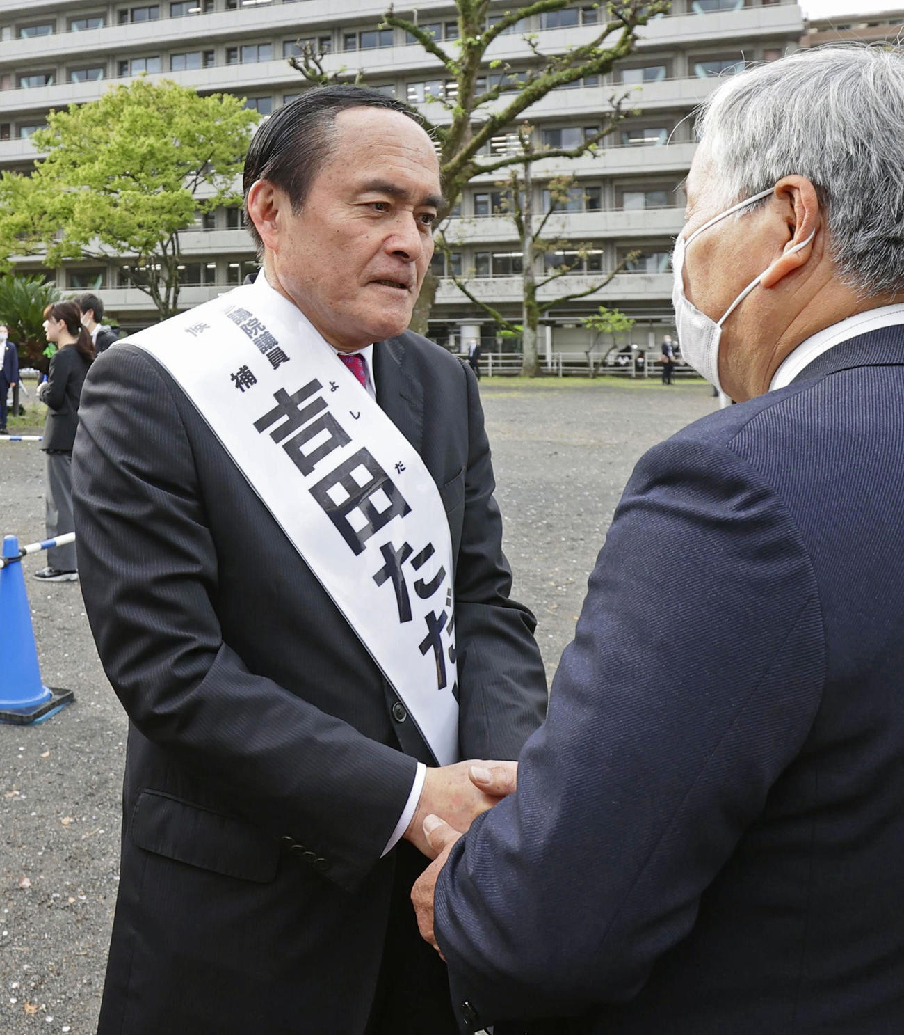 参院大分選挙区補欠選挙が告示され、有権者と握手する吉田忠智氏（共同）