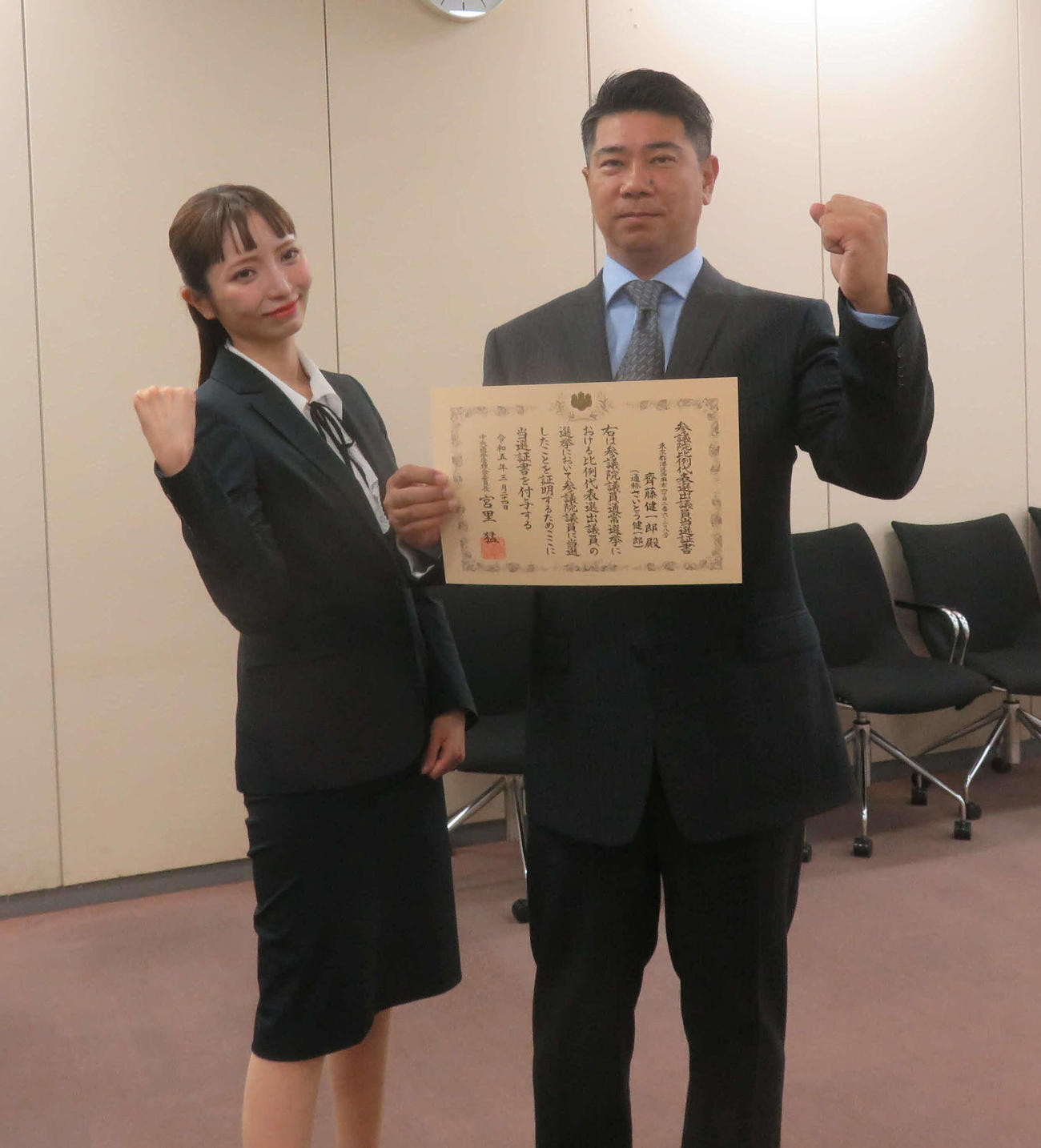 当選証書を手に大津綾香氏とポーズを決める斉藤健一郎氏（2023年3月24日撮影）