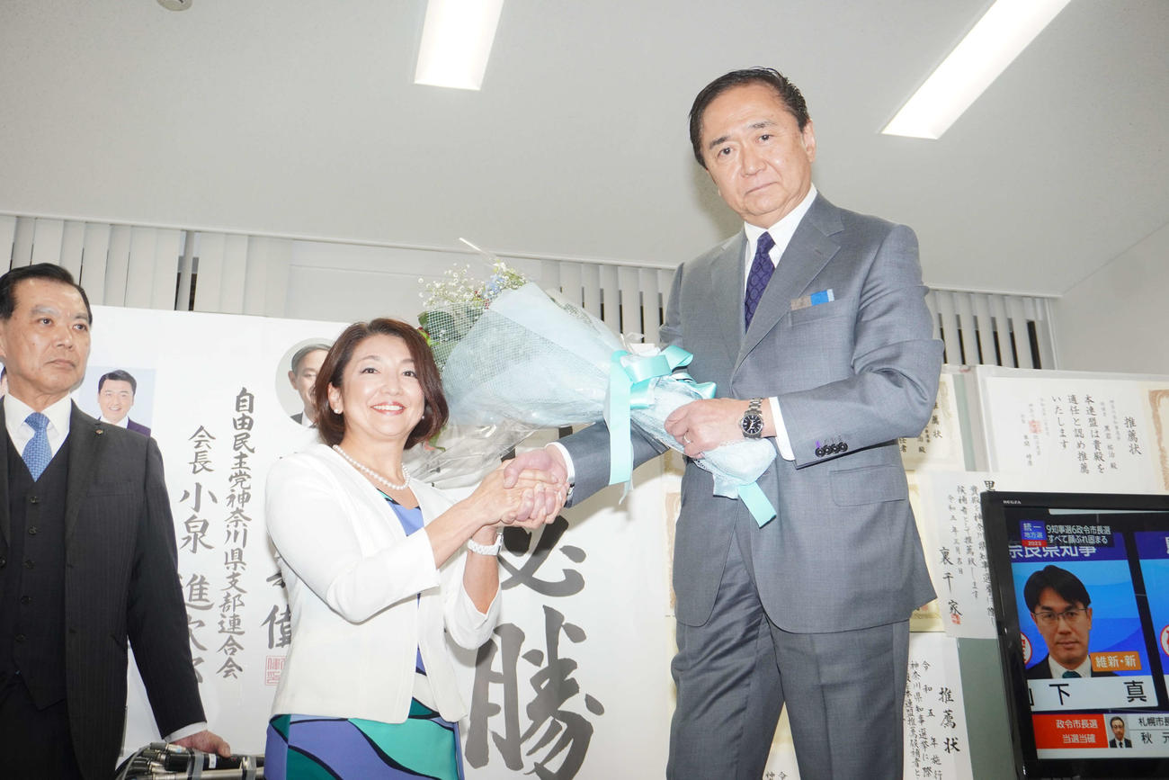 当選確実の報を受け、選挙スタッフから花束を受け取るも厳しい表情の黒岩祐治知事（撮影・沢田直人）