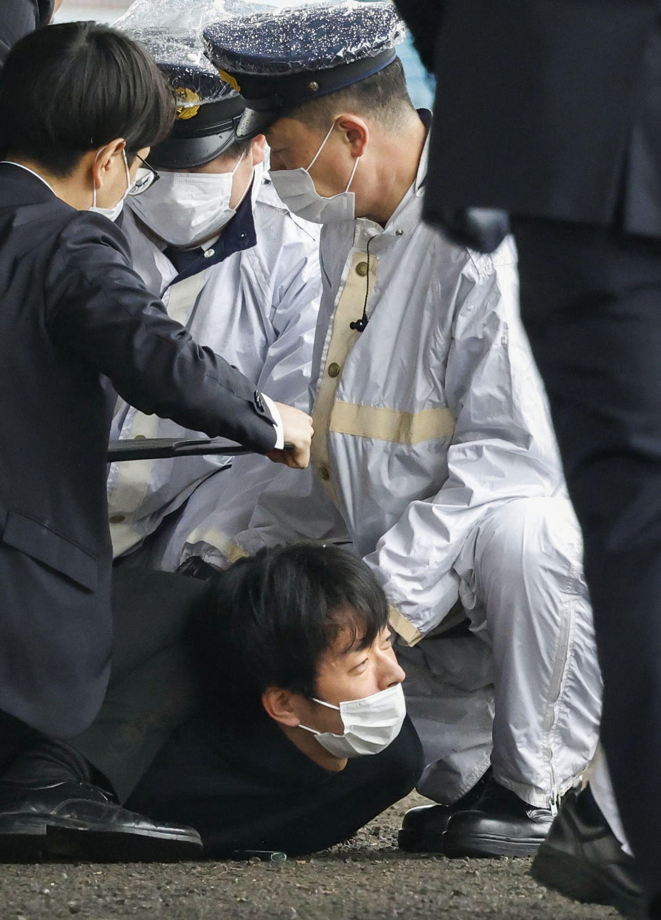 岸田首相が応援演説に訪れた和歌山市の雑賀崎漁港で、筒状のものが投げ込まれ爆発し、取り押さえられる木村隆二容疑者（下）＝15日午前11時31分（共同）