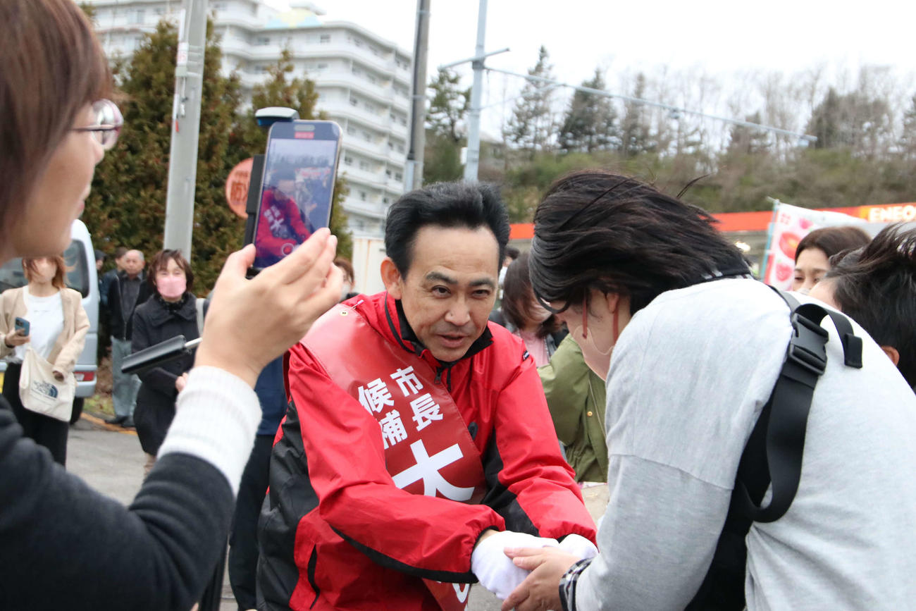 街頭演説後に市民と握手する大泉潤氏（撮影・山崎純一）