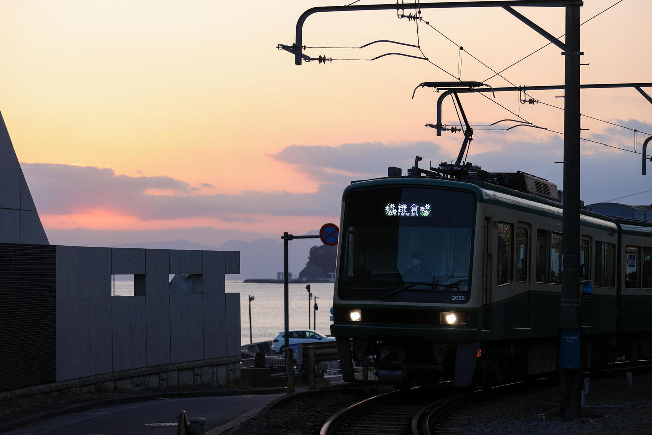 稲村ヶ崎ー七里ガ浜間、夕日を浴びて走る江ノ電（撮影・大野祥一）