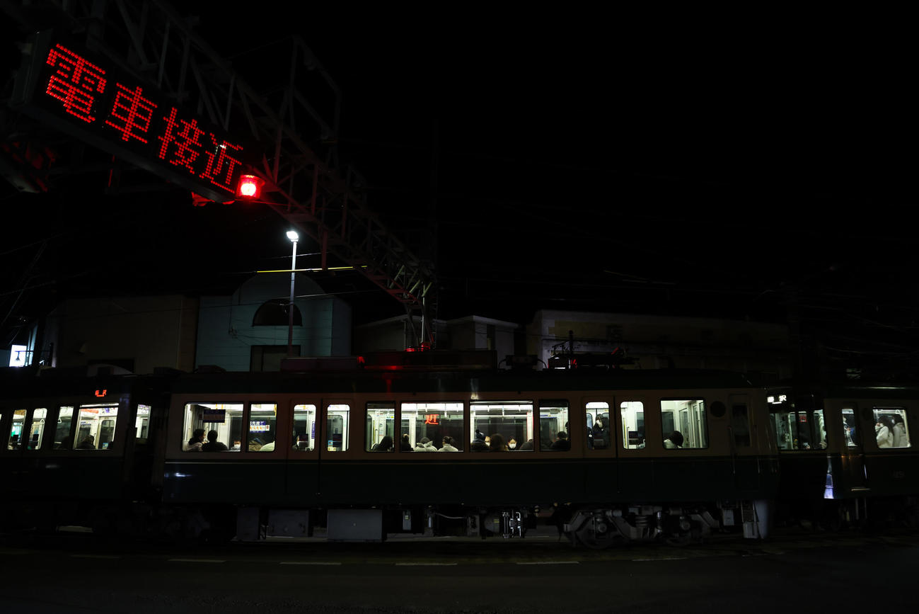 江ノ島駅付近、接近警告が表示され、道路を横切る江ノ電（撮影・大野祥一）
