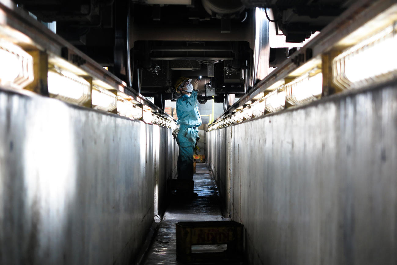 車両の下にもぐり、検査する（撮影・大野祥一）